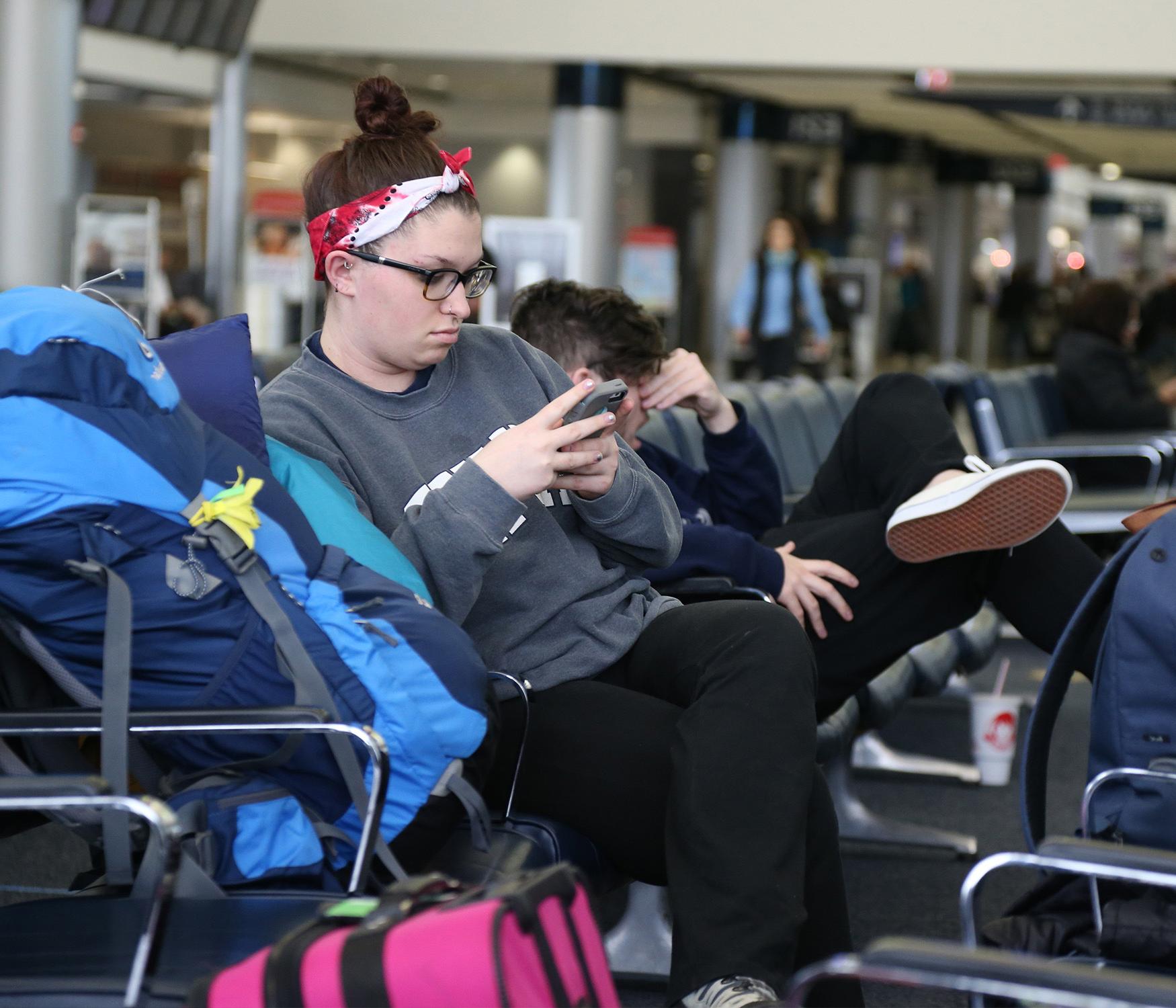 Xavier student sitting at a terminal at the Covington airport