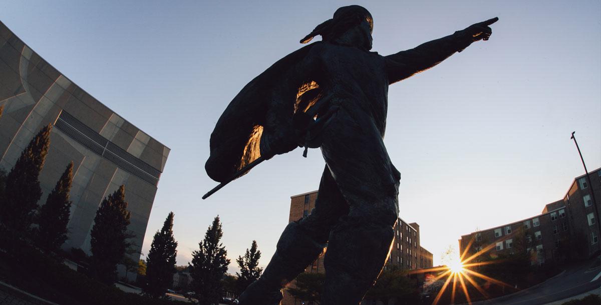 The D'Artagnan Statue in front of Cintas Center points it's finger toward the sky while the sun sets.