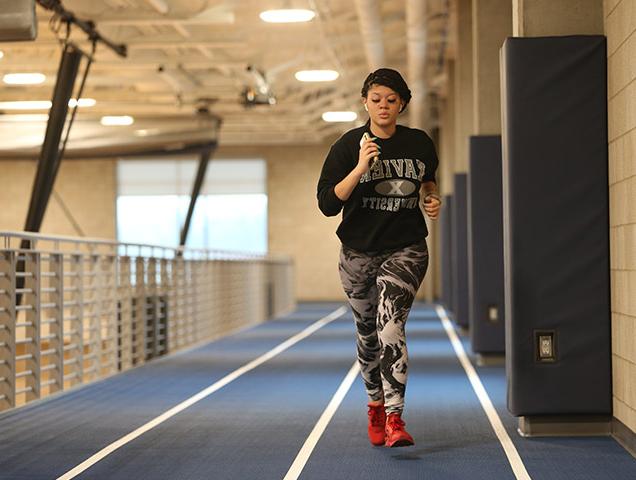 Student in the sport marketing major running on an indoor track in Xavier's recreation center