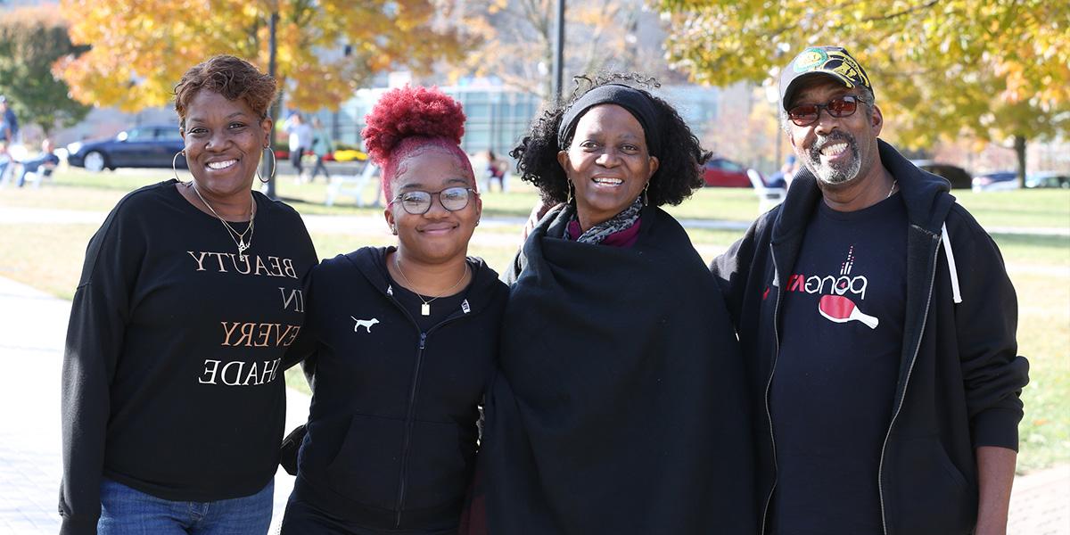 A Xavier family smiling together on campus
